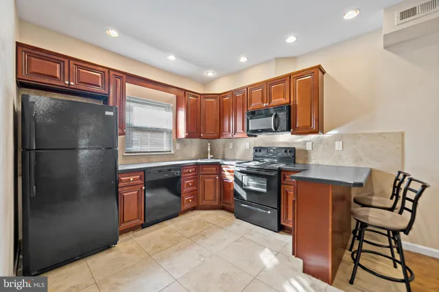 a kitchen with stainless steel appliances granite countertop a refrigerator stove and a sink