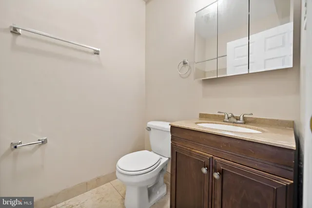a bathroom with a granite countertop toilet sink and mirror