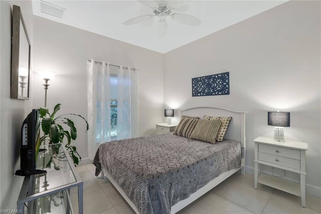 3892 14th Street North Naples, FL 34103 - Photo 10 of 19 a bedroom with a bed and a chandelier