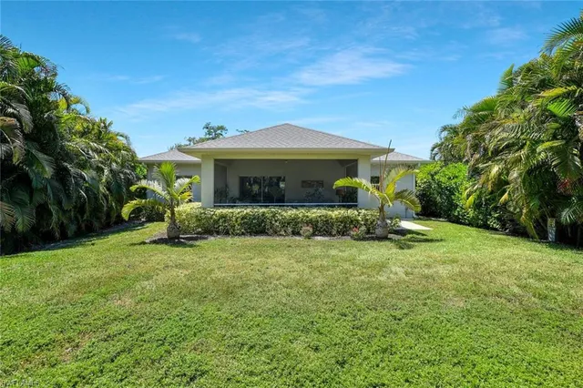 a living room with patio furniture and a potted plant