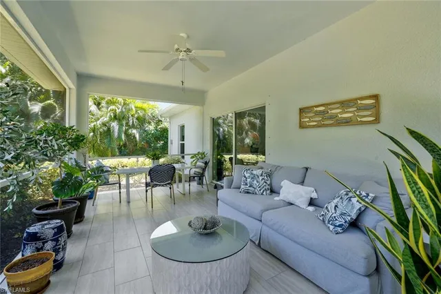a living room with furniture potted plant and a large window