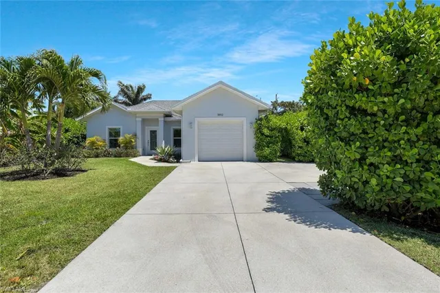 a front view of a house with a yard and trees