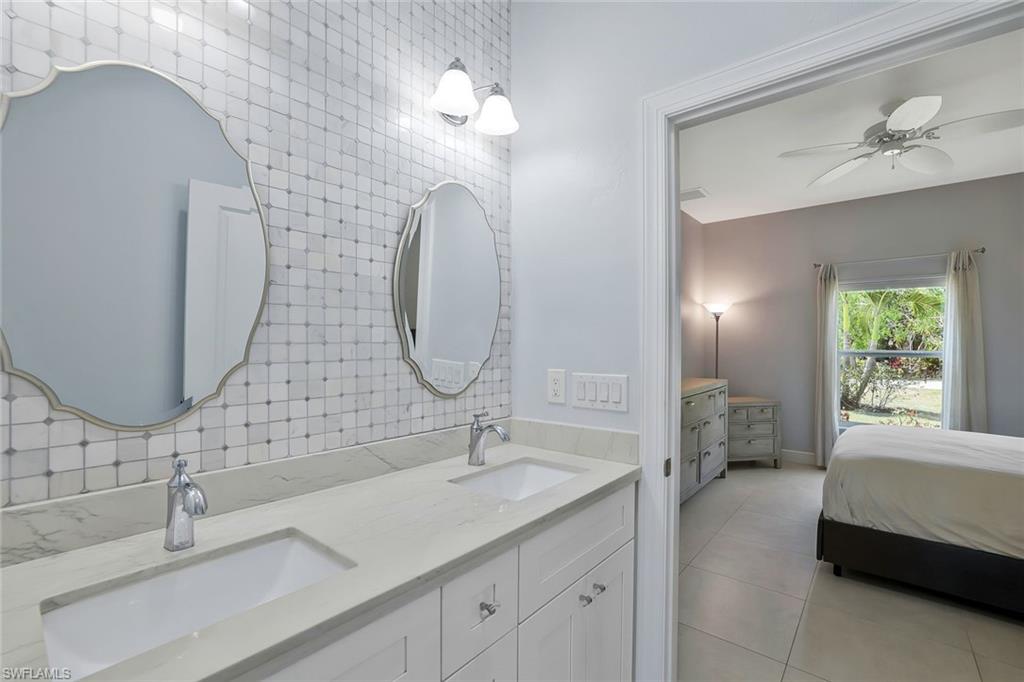 3892 14th Street North Naples, FL 34103 - Photo 9 of 19 a en suite bathroom with a double vanity sink and a mirror