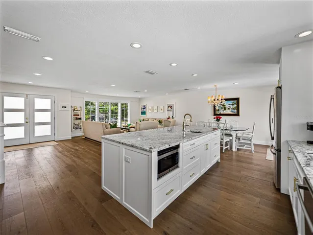 a backyard of a house with table and chairs under an umbrella