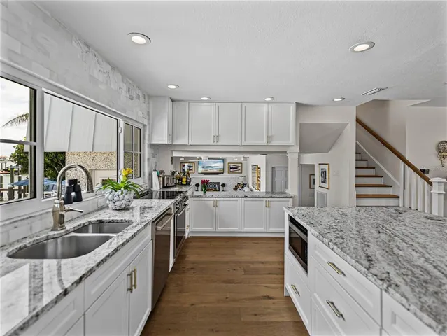 a view of a patio with table and chairs potted plants and palm trees