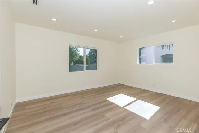 a view of an empty room with wooden floor
