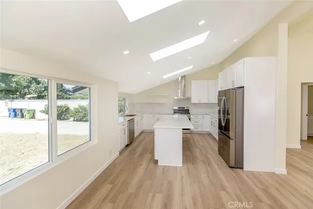 a kitchen with stainless steel appliances granite countertop a refrigerator and a stove top oven