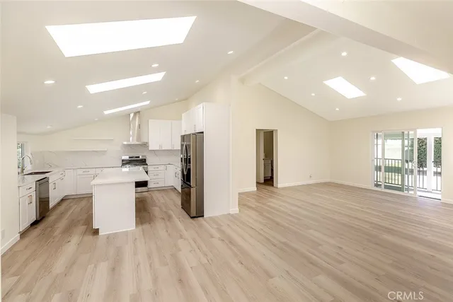 a view of a kitchen with refrigerator microwave and wooden floor