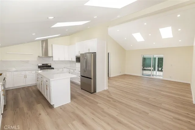 a kitchen with a refrigerator and a stove top oven
