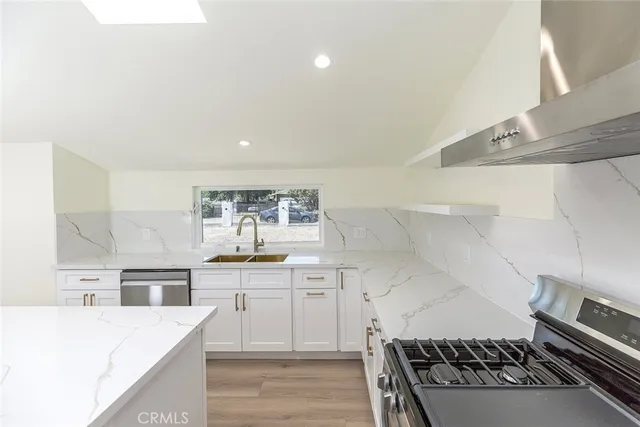 a kitchen with granite countertop a stove and a sink