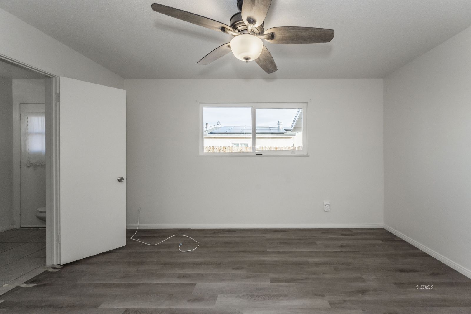 412 East Church Avenue Ridgecrest, CA 93555 - Photo 25 of 39 an empty room with wooden floor chandelier fan and windows