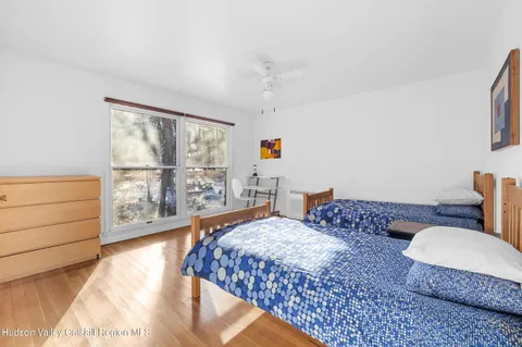 a bedroom with a bed a chandelier and a view of balcony
