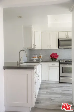 a kitchen with stainless steel appliances granite countertop a sink and cabinets