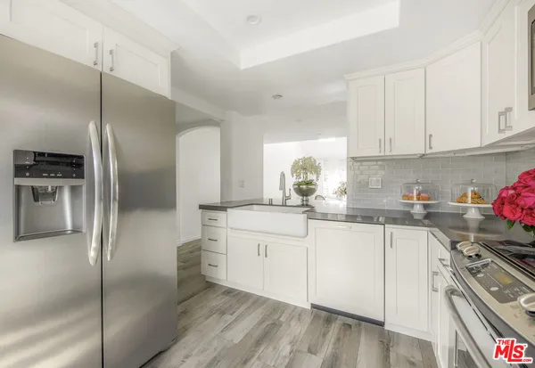 a kitchen with white cabinets and stainless steel appliances
