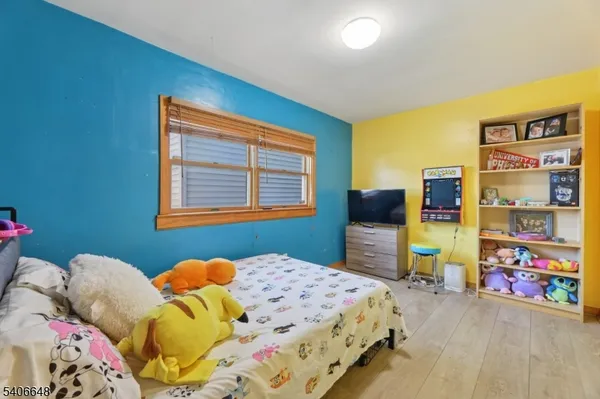 a bedroom with bed and wooden floor