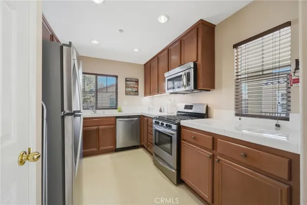 a kitchen with stainless steel appliances granite countertop a stove a sink and a refrigerator