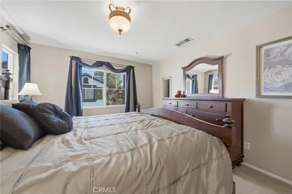a bedroom with a bed and dresser with mirror
