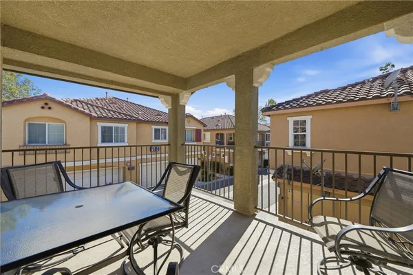 a view of a balcony with two chairs and wooden floor