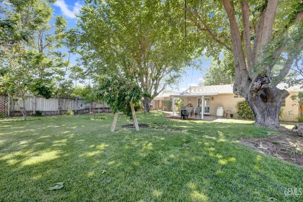 a view of a house with a big yard and large trees