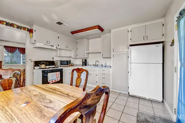 a kitchen with granite countertop a refrigerator and a stove top oven