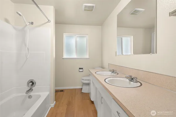 a bathroom with a sink double vanity granite tub and a mirror