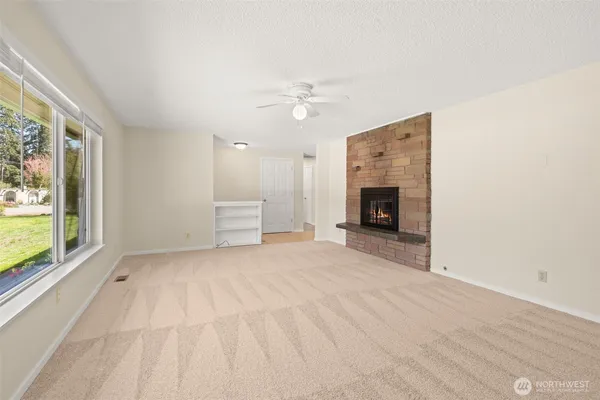 an empty room with fireplace cabinet and windows