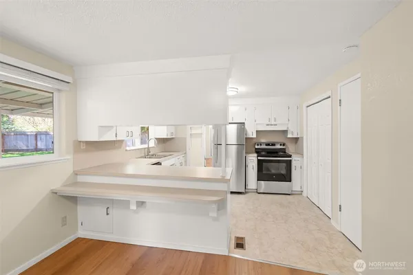 a kitchen with a sink stainless steel appliances and white cabinets