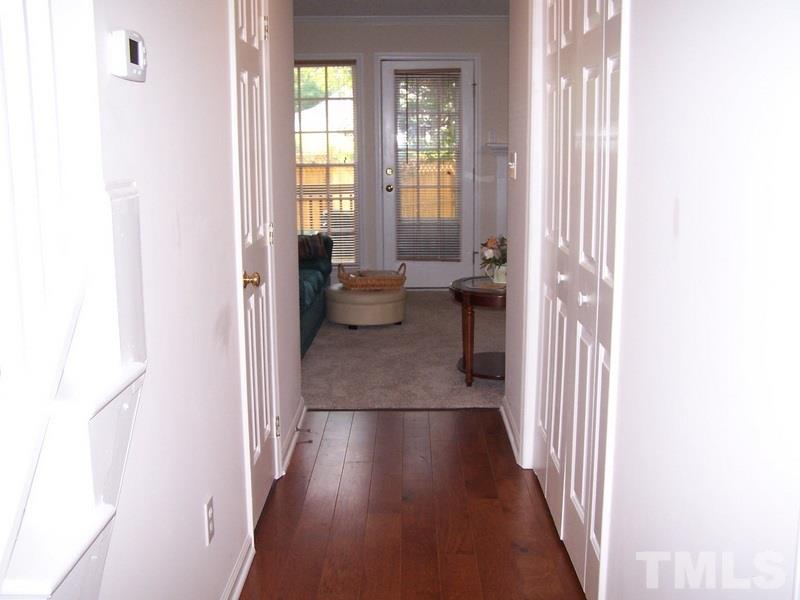 3811 Axle Lane Raleigh, NC 27616 - Photo 3 of 24 a view of a hallway with wooden floor and a living room