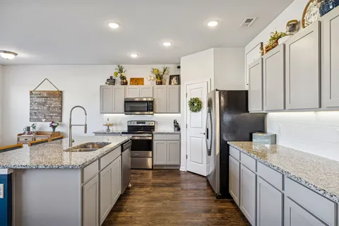 a kitchen with stainless steel appliances granite countertop a sink stove and refrigerator