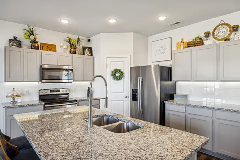a kitchen with stainless steel appliances granite countertop a refrigerator sink and stove