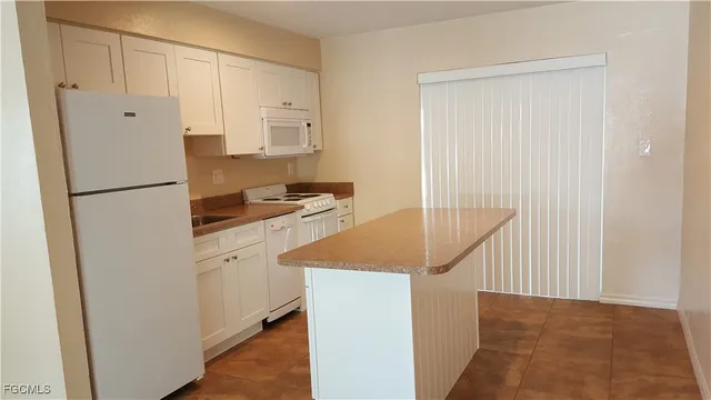a kitchen with white cabinets and white appliances
