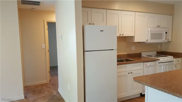 a kitchen with cabinets and stainless steel appliances