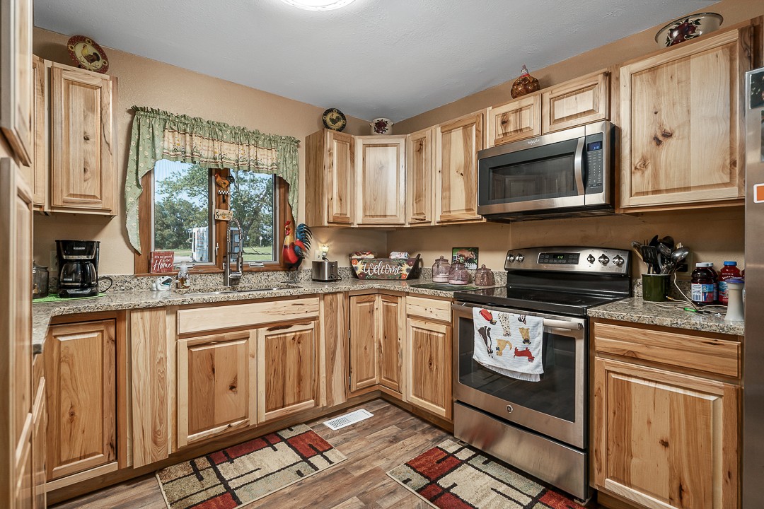 2711 Sullivan Knowles Road Sparta, TN 38583 - Photo 26 of 42 a kitchen with stainless steel appliances granite countertop a stove a sink and a microwave