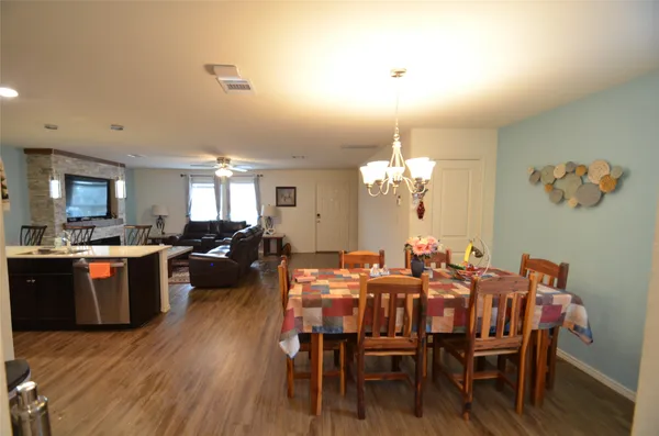 a view of a dining room with furniture a chandelier and wooden floor