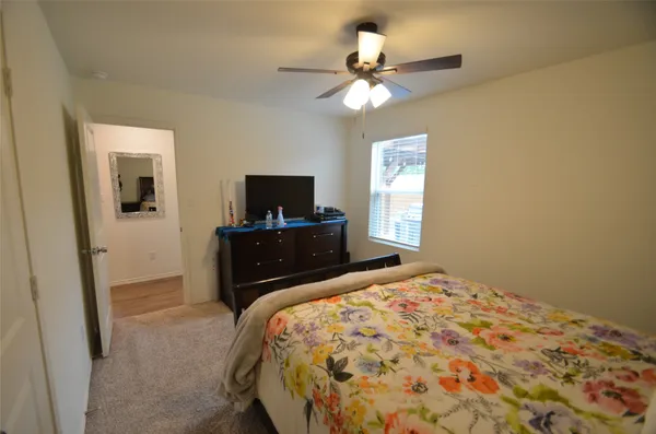 a bedroom with a bed and a flat tv screen on dresser