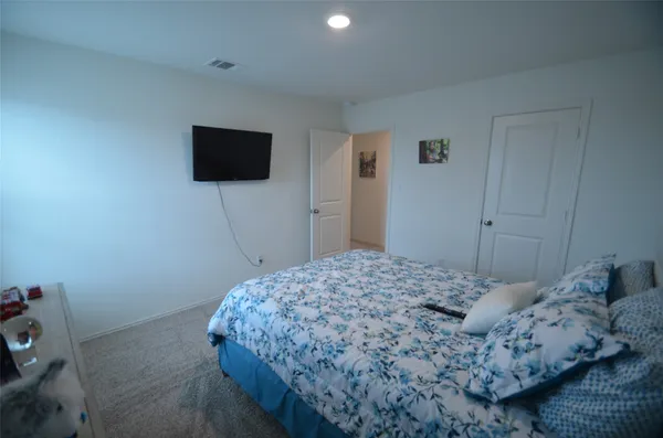a bedroom with a bed and a flat screen tv