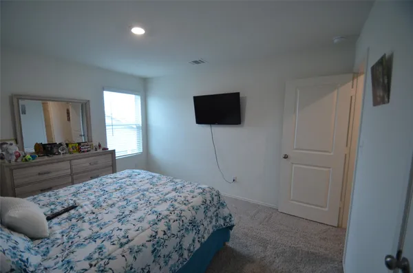 a bedroom with a bed and a flat screen tv