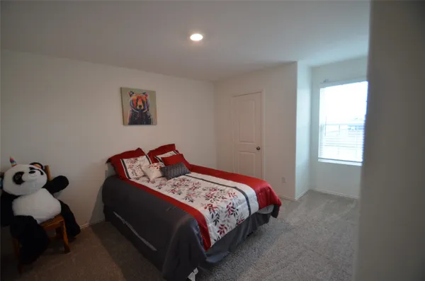 a bed sitting in a bedroom next to a window