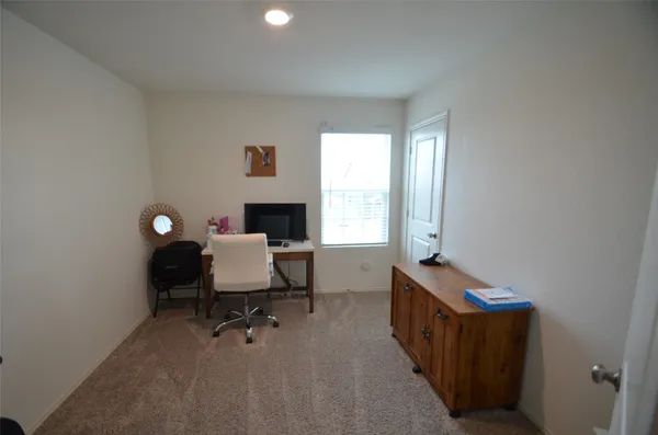 a view of a workspace with furniture and a window