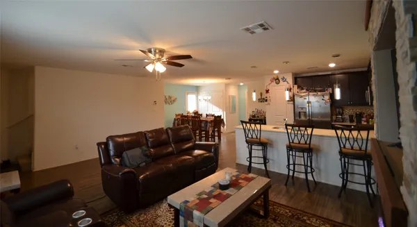 a living room with furniture a ceiling fan and a rug