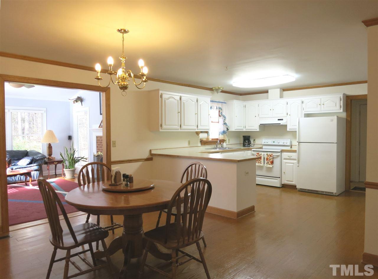 4300 Quarry Road Zebulon, NC 27597 - Photo 7 of 25 a kitchen with refrigerator a dining table and chairs