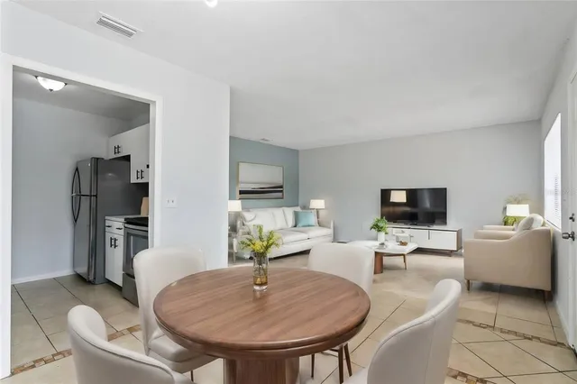 a living room with furniture a flat screen tv and kitchen view