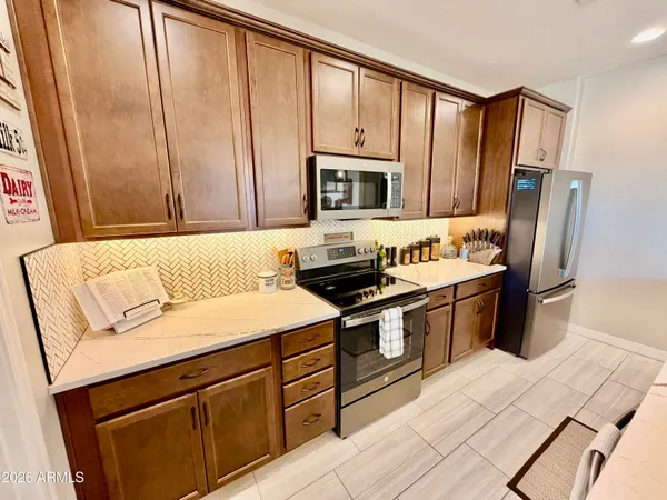 a kitchen with stainless steel appliances granite countertop a refrigerator stove and sink