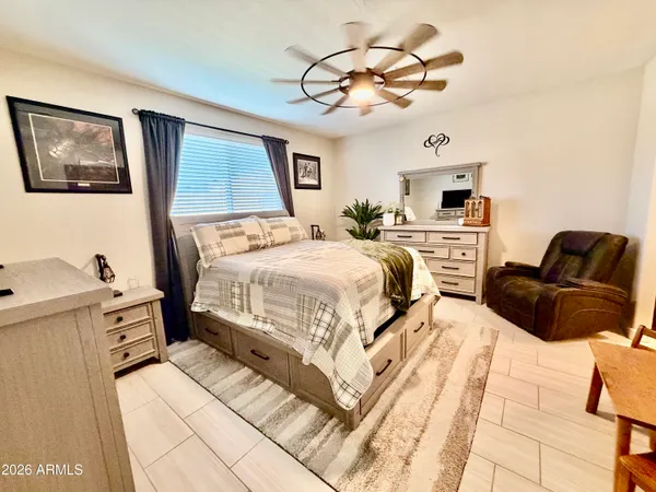a bedroom with a bed a couch and chandelier