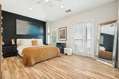 a bedroom with a large bed and wooden floor