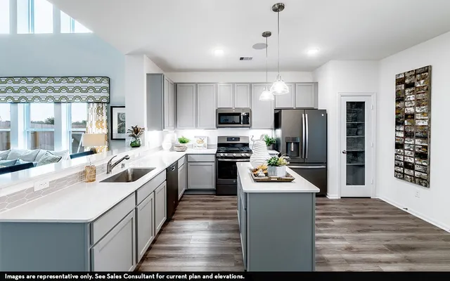a kitchen with stainless steel appliances kitchen island a refrigerator sink and cabinets