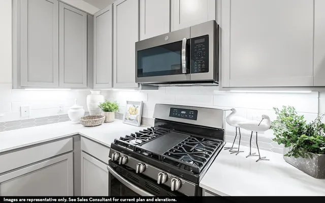 a kitchen with granite countertop a table chairs stove and sink