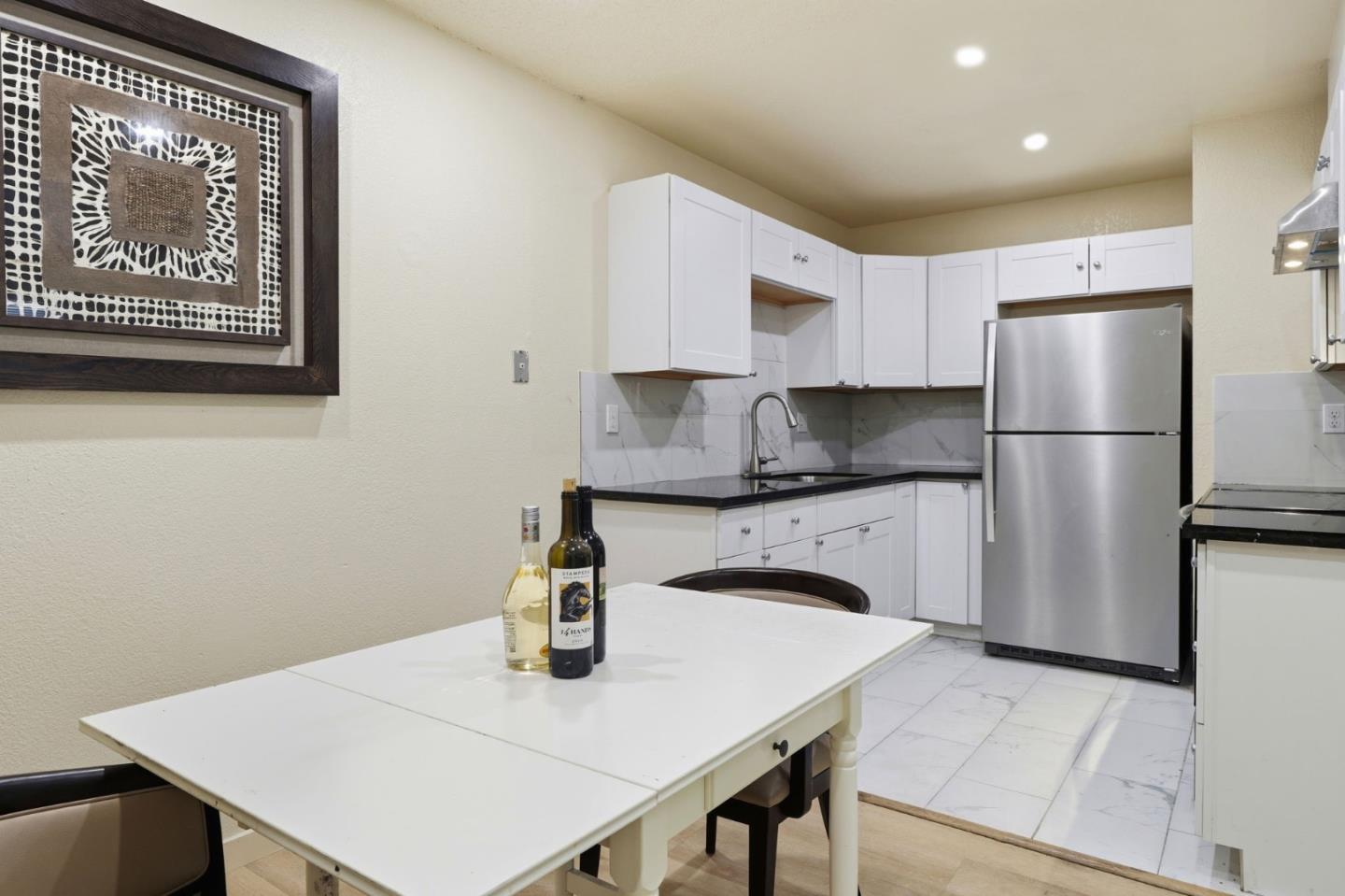 7283 Florin Road, Unit 8 Sacramento, CA 95828 - Photo 20 of 35 a kitchen with a refrigerator a stove a sink and white cabinets with wooden floor