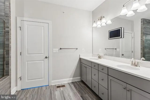 a spacious bathroom with a double vanity sink and mirror