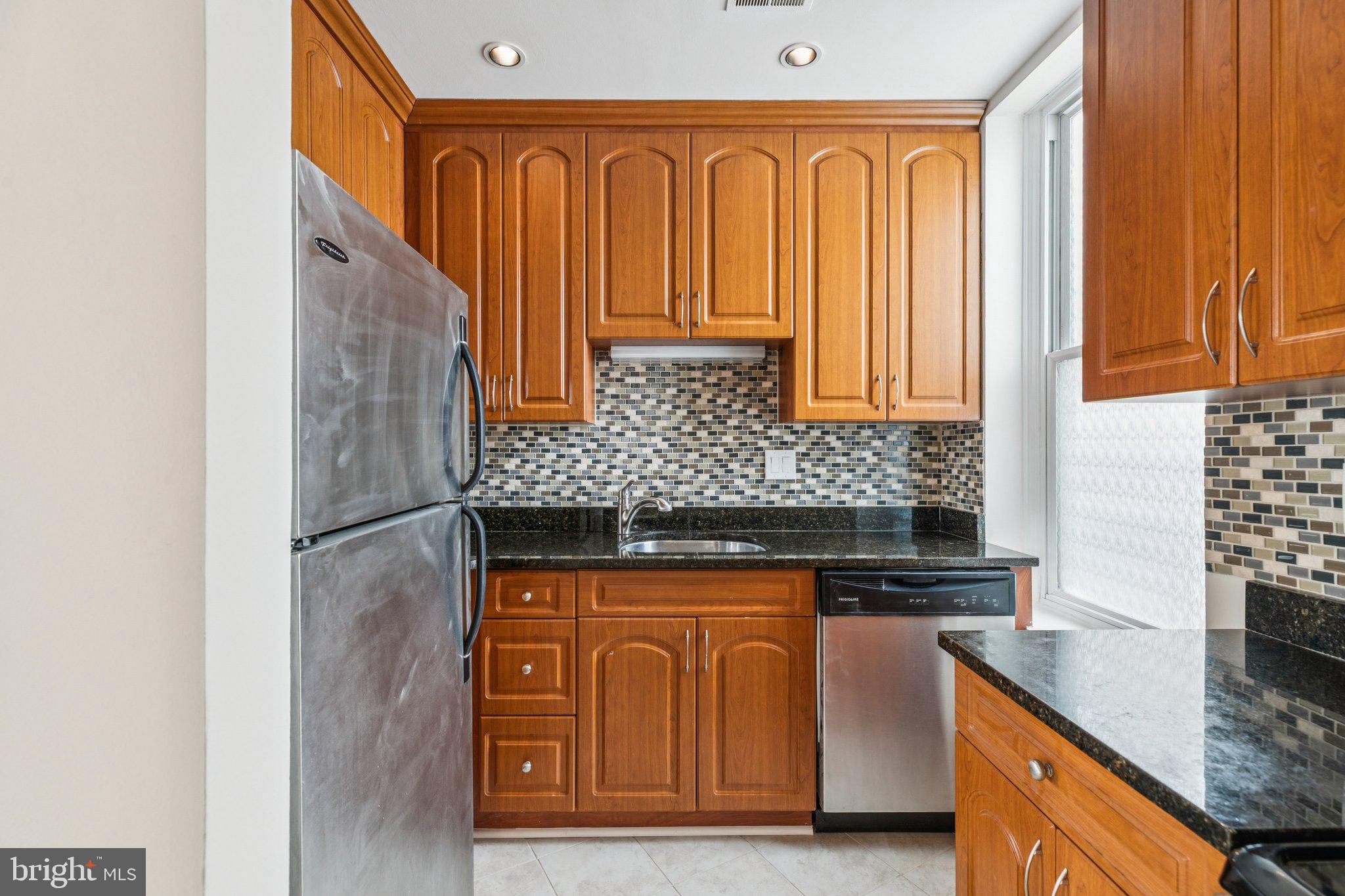1703 Wallace Street, Unit 301 Philadelphia, PA 19130 - Photo 6 of 22 a kitchen with stainless steel appliances granite countertop a stove and a refrigerator